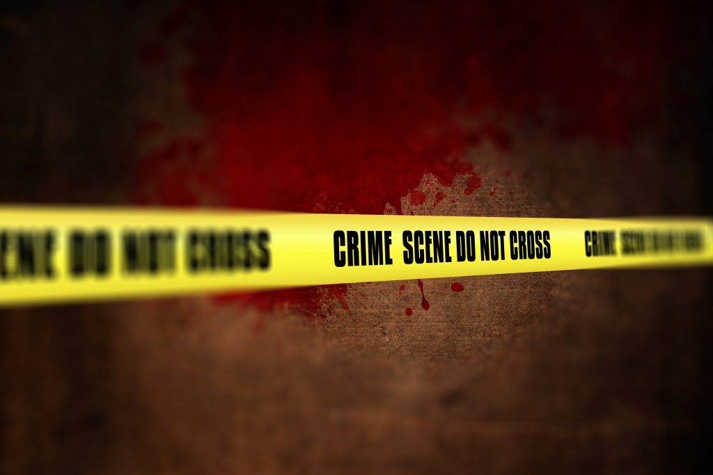 Crime scene tape with blood splatters – do not cross warning at murder site