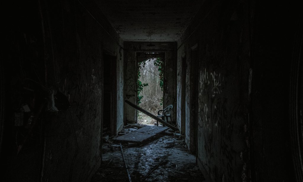 Dark abandoned hallway with broken furniture — evoking mystery, urban decay, and hidden crime locations often explored in true crime documentaries.

